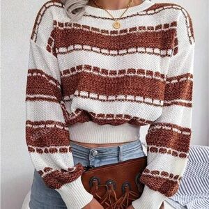 This is a white and dark orange cropped sweater
